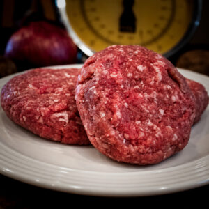 Raw Beef Patties on a White Plate