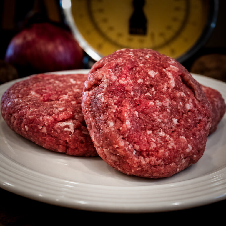 Raw Beef Patties on a White Plate